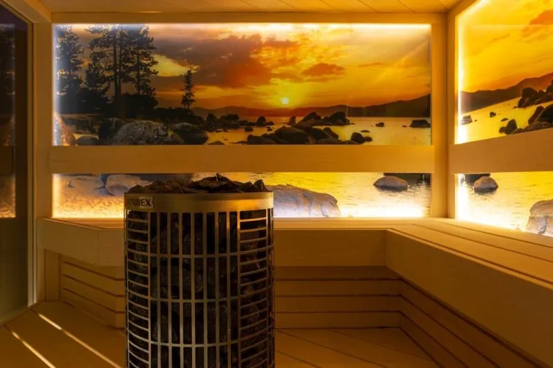 Sauna heater filled with stones in a lit cabin